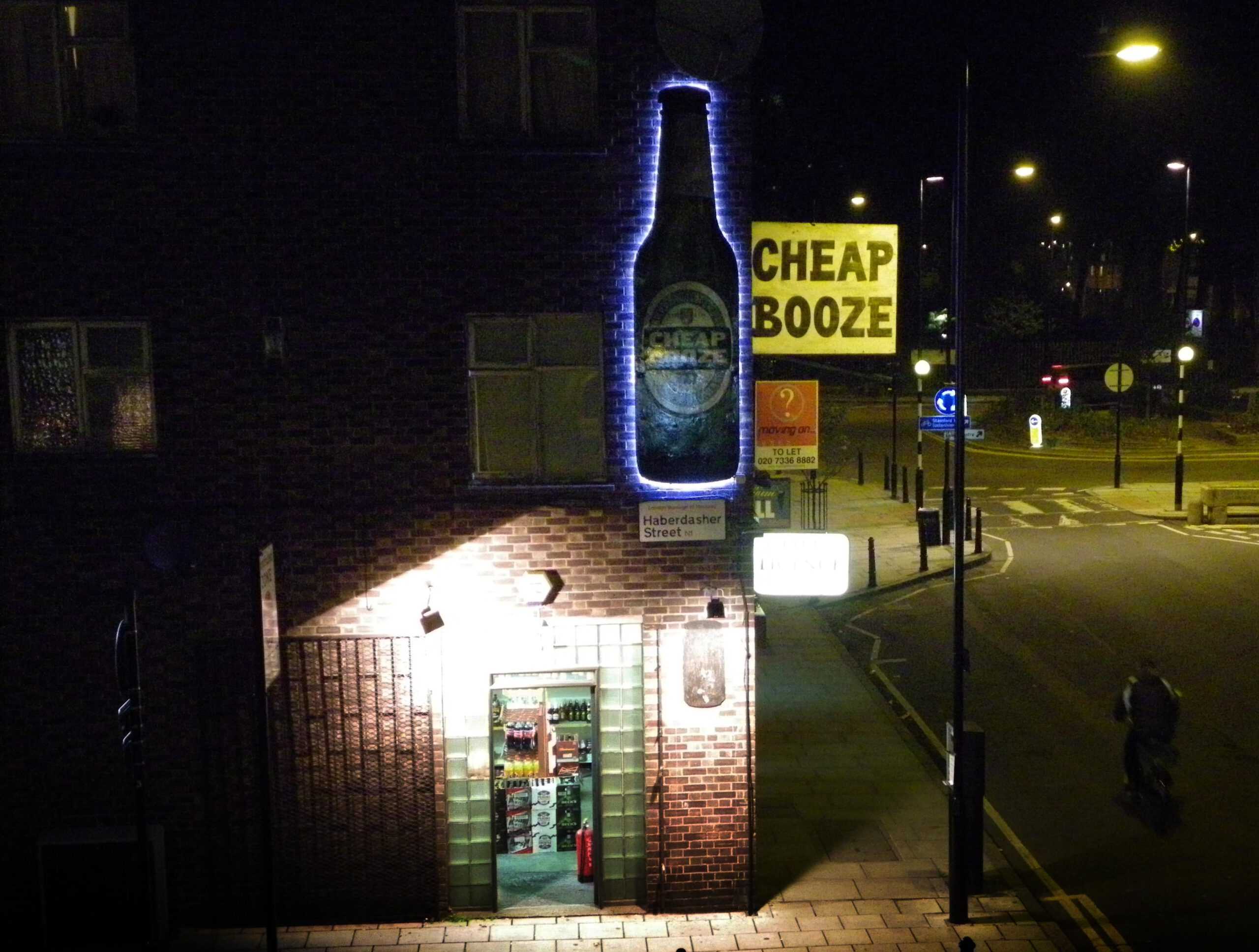 Wide street view of newly refurbished and illuminated sign.